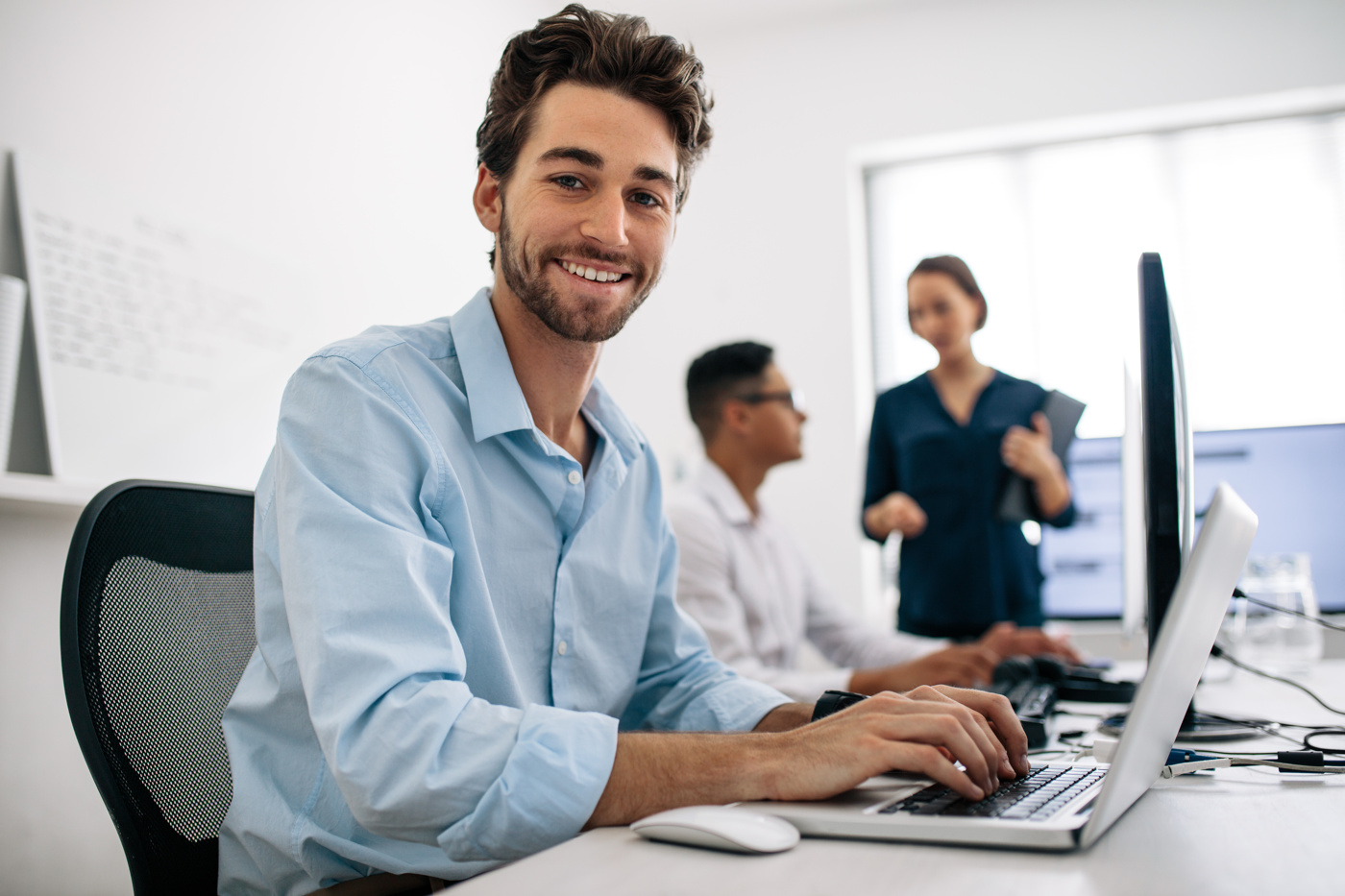 Mann arbeitet an seinem Laptop und löst Aufgaben für sein Informatik Studium an einer Fachhochschule.