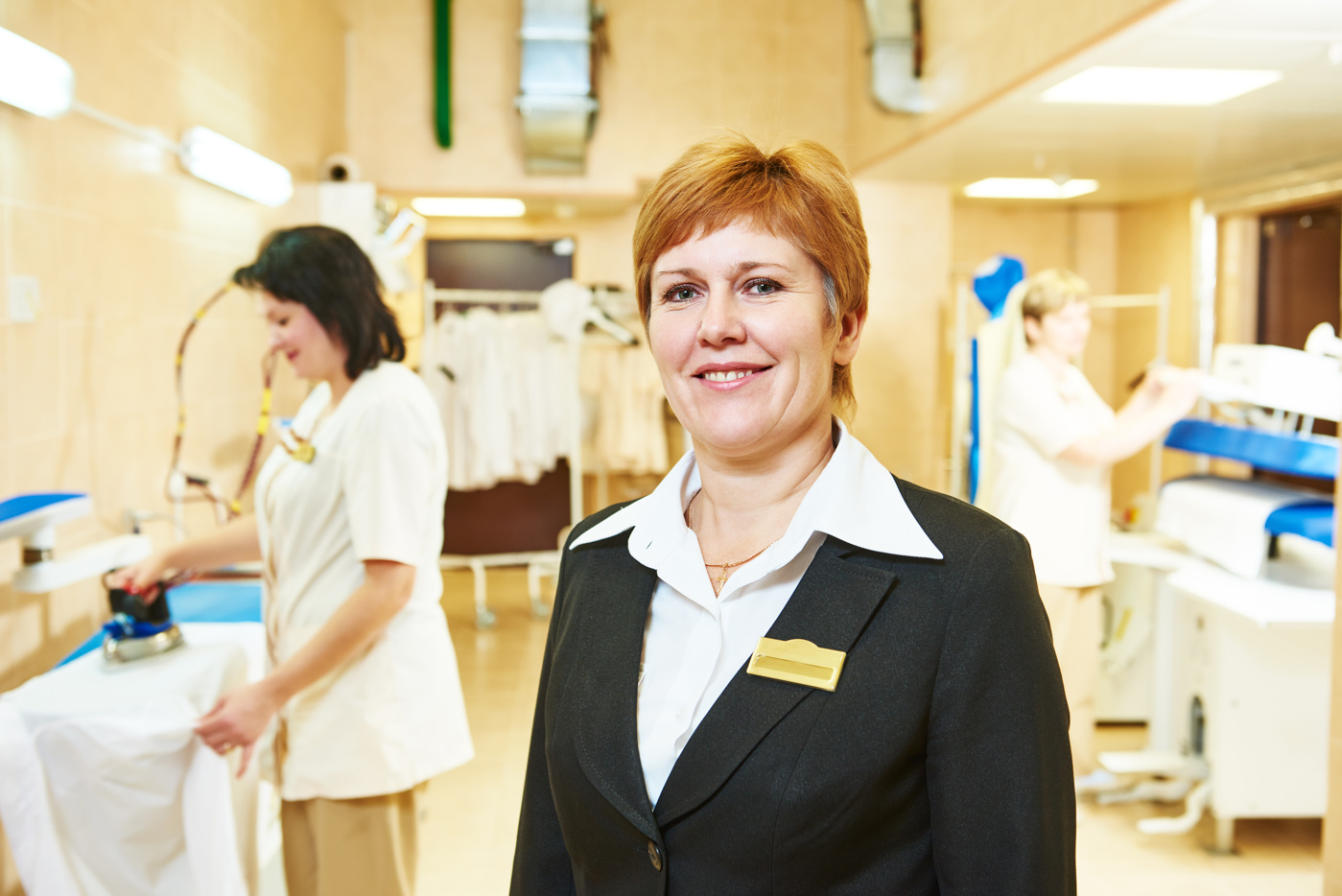 Eine Bereichsleiterin Hotellerie-Hauswirtschaft stattet den Mitarbeitern/-innen der Laundry einen Besuch ab.