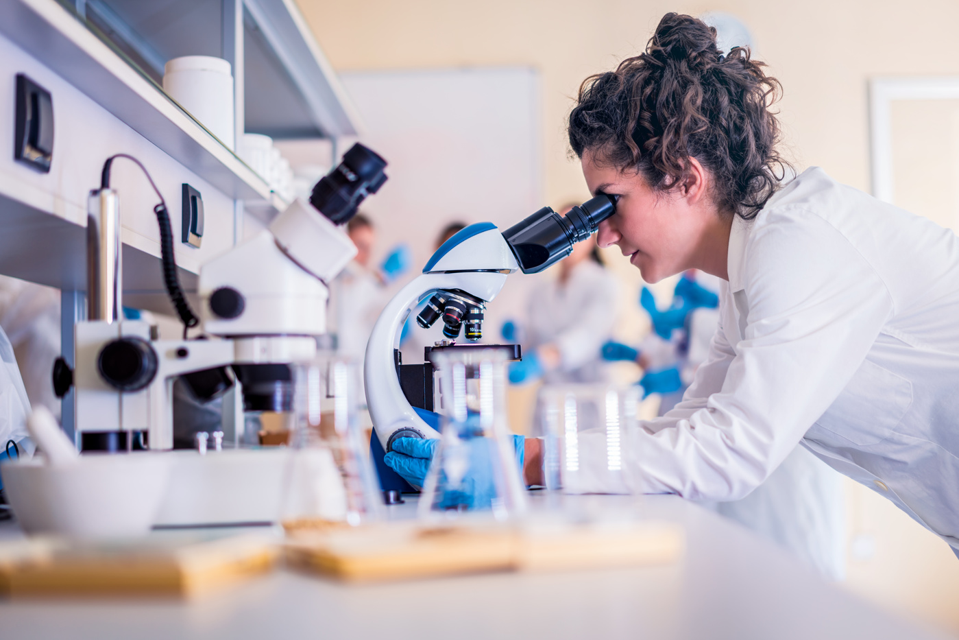 Eine Biomedizinische Analytikerin HF analysiert eine Gewebeprobe unter dem Mikroskop.