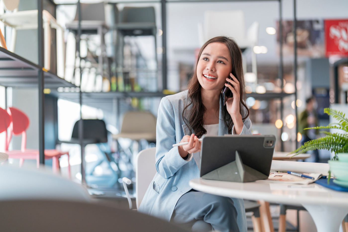 Eine E-Commerce Spezialistin telefoniert mit einem Händler, dessen Ware sie im Online-Shop aufführen möchte.