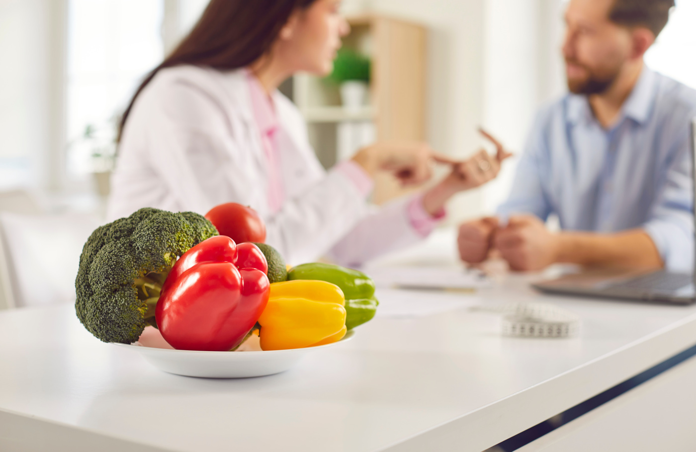 Eine Ernährungsberaterin zeigt einem Klienten die Vorteile einer bewussten und gesunden Ernährung.