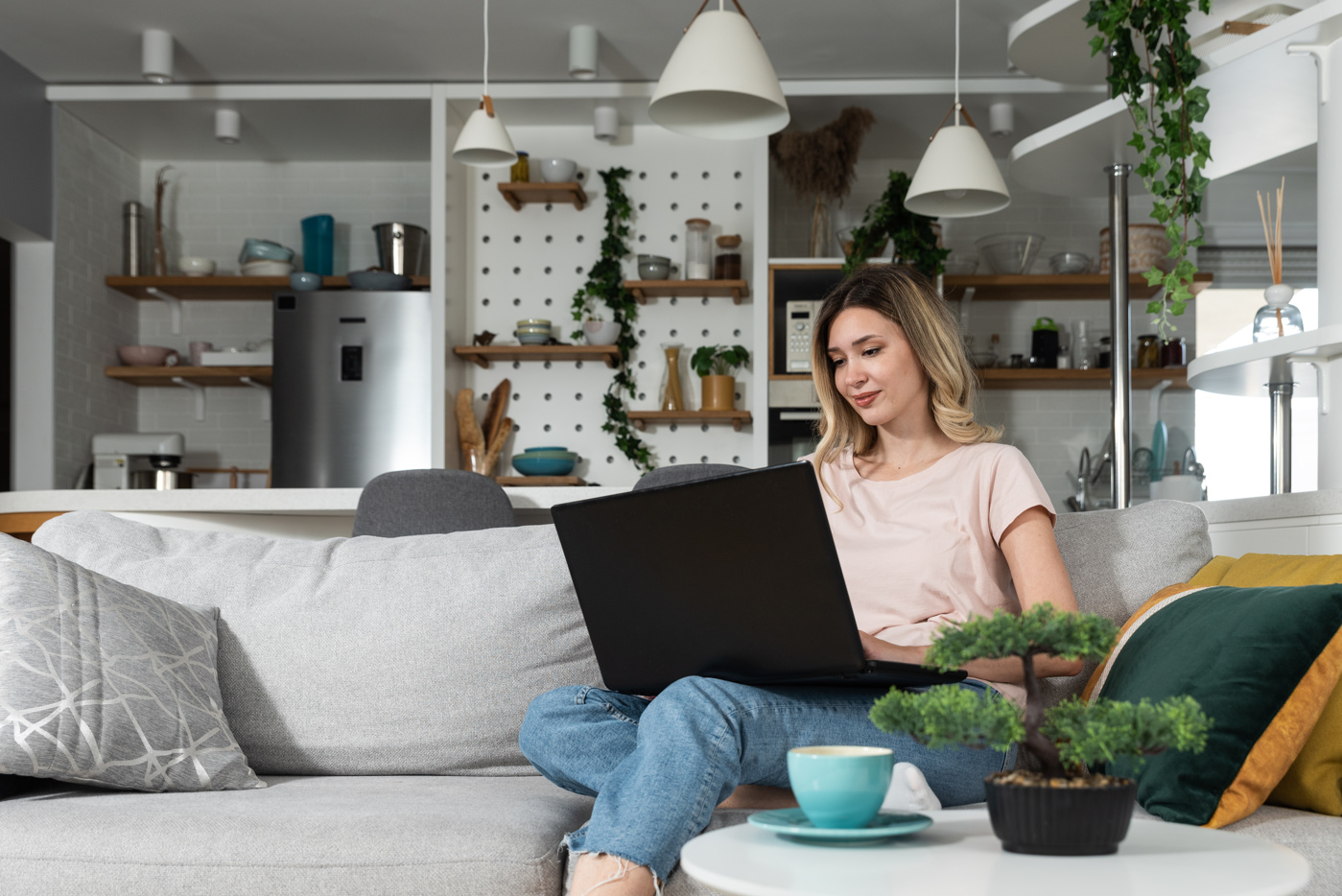 Feng Shui Beratung: Ausbildung, Kurs, Weiterbildung, Lehrgang Eine Frau sitzt auf dem Sofa und sucht im Internet nach Feng Shui-Möbeln.