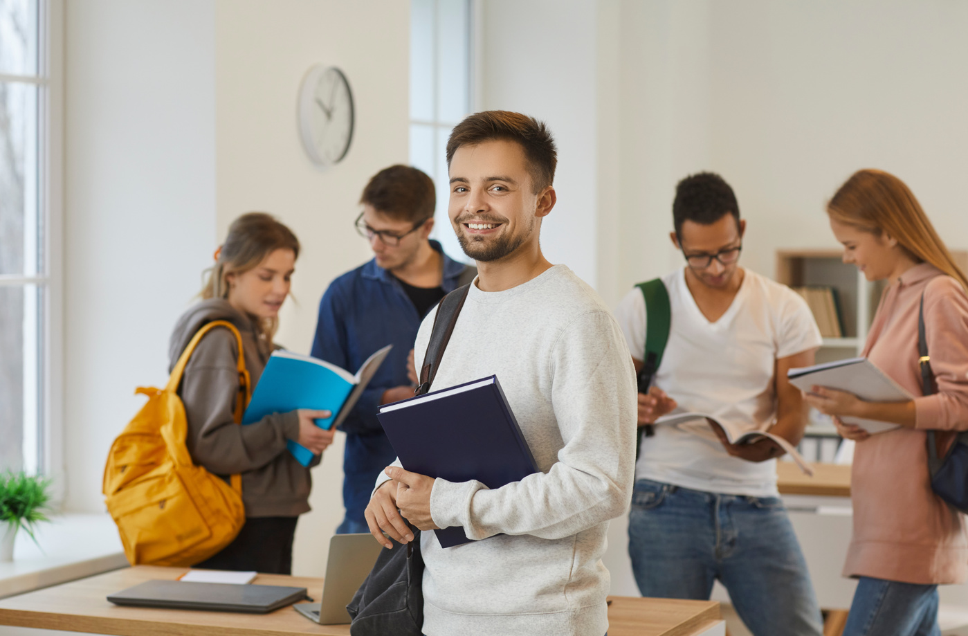 Schüler und Schülerinnen einer Handelsdiplom Weiterbildung unterhalten sich im Klassenzimmer miteinander.