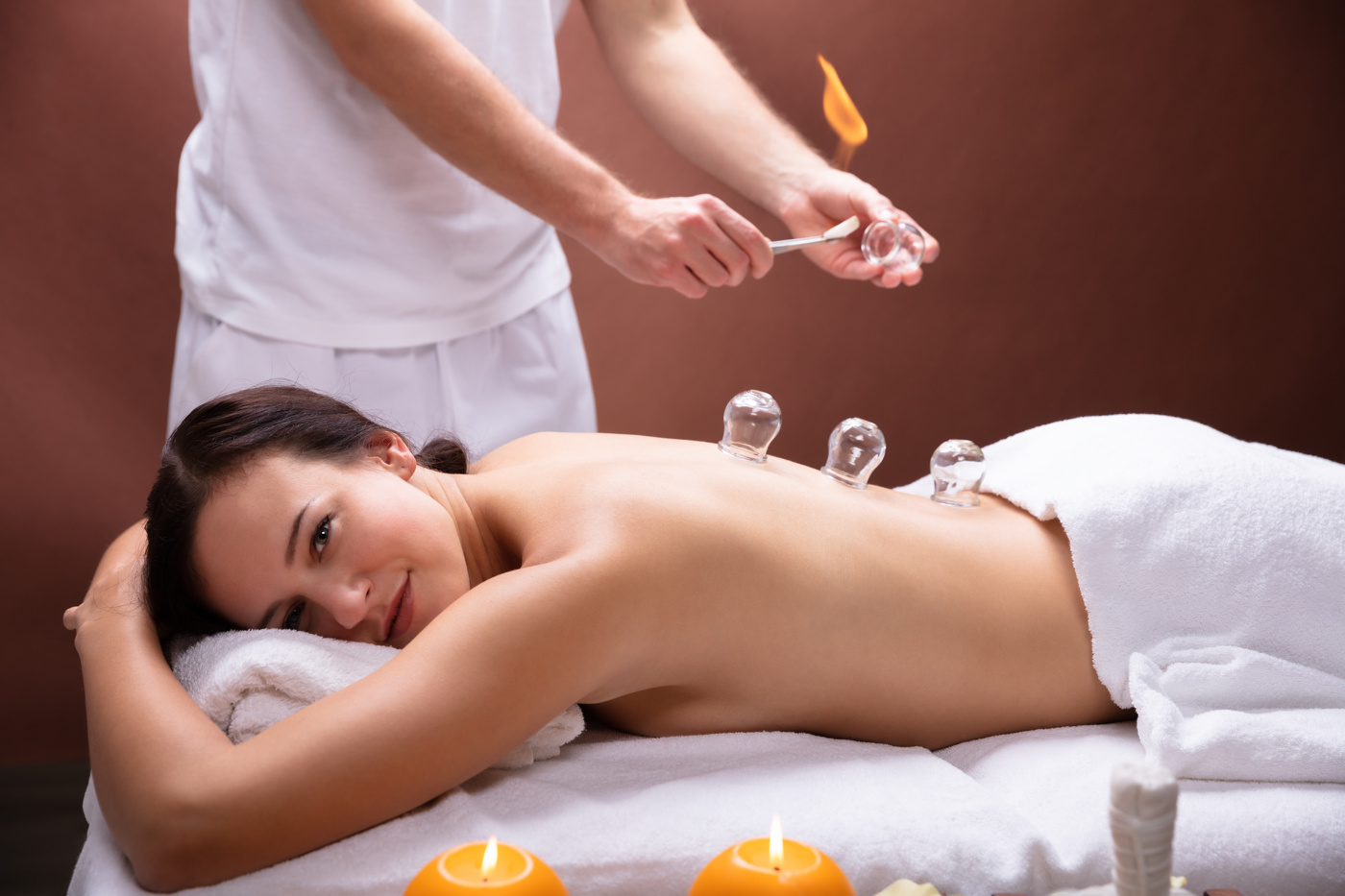 Ein Naturheilpraktiker mit eidg. Diplom behandelt eine Patientin mit Schröpfen, eine bewährte Heilmethode der Traditionellen Chinesischen Medizin (TCM).