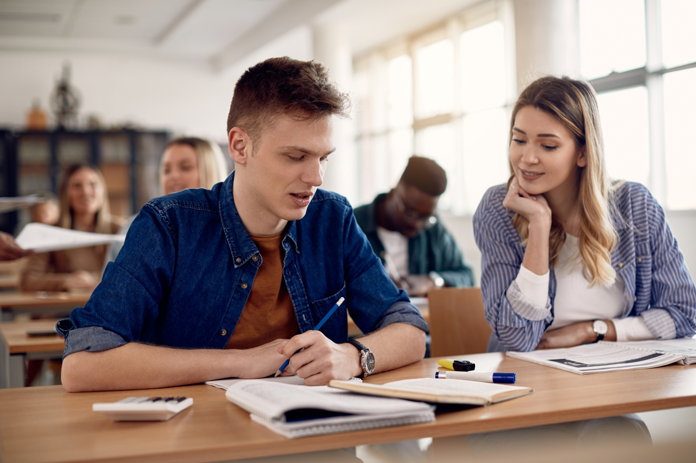 Schüler und Schülerinnen einer Ausbildung zum Höheren Wirtschaftsdiplom VSK im Schulzimmer am Lernen.
