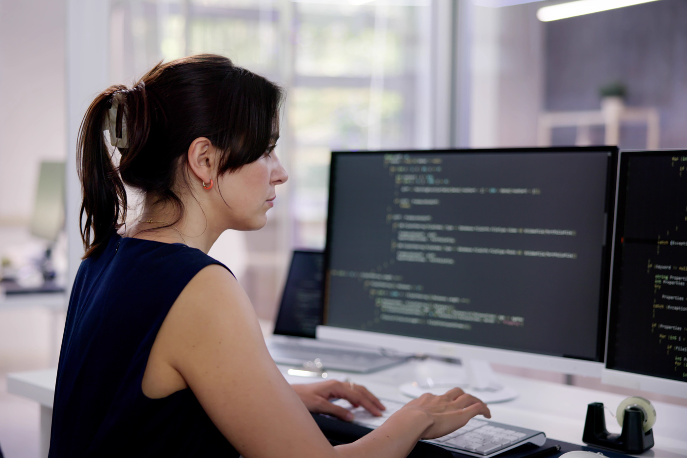 Eine ICT-Applikationsentwicklerin mit eidg. Fachausweis kontrolliert den Programmier-Code.
