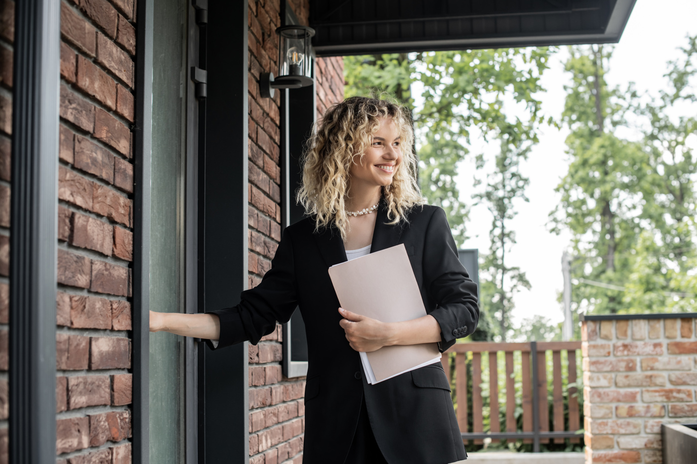 Eine Immobilien-Treuhänderin mit eidg. Diplom öffnet ein Haus für die Kundschaft.
