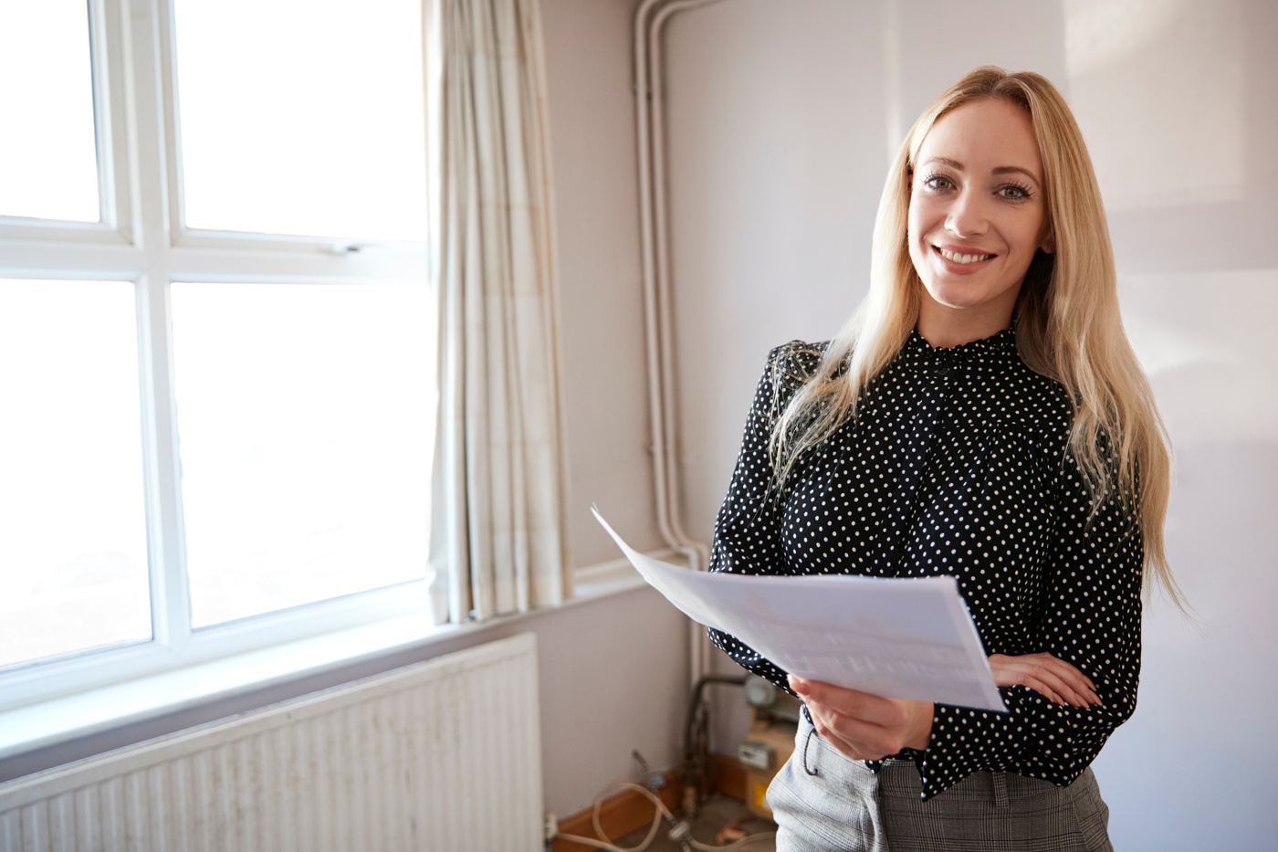 Eine Immobilienentwicklerin begutachtet eine Immobilie für eine markttaugliche Umnutzung.