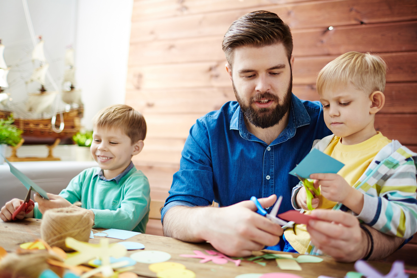 Ein Kindheitspädagoge HF bastelt mit Kindern in einer Betreuungsstätte.