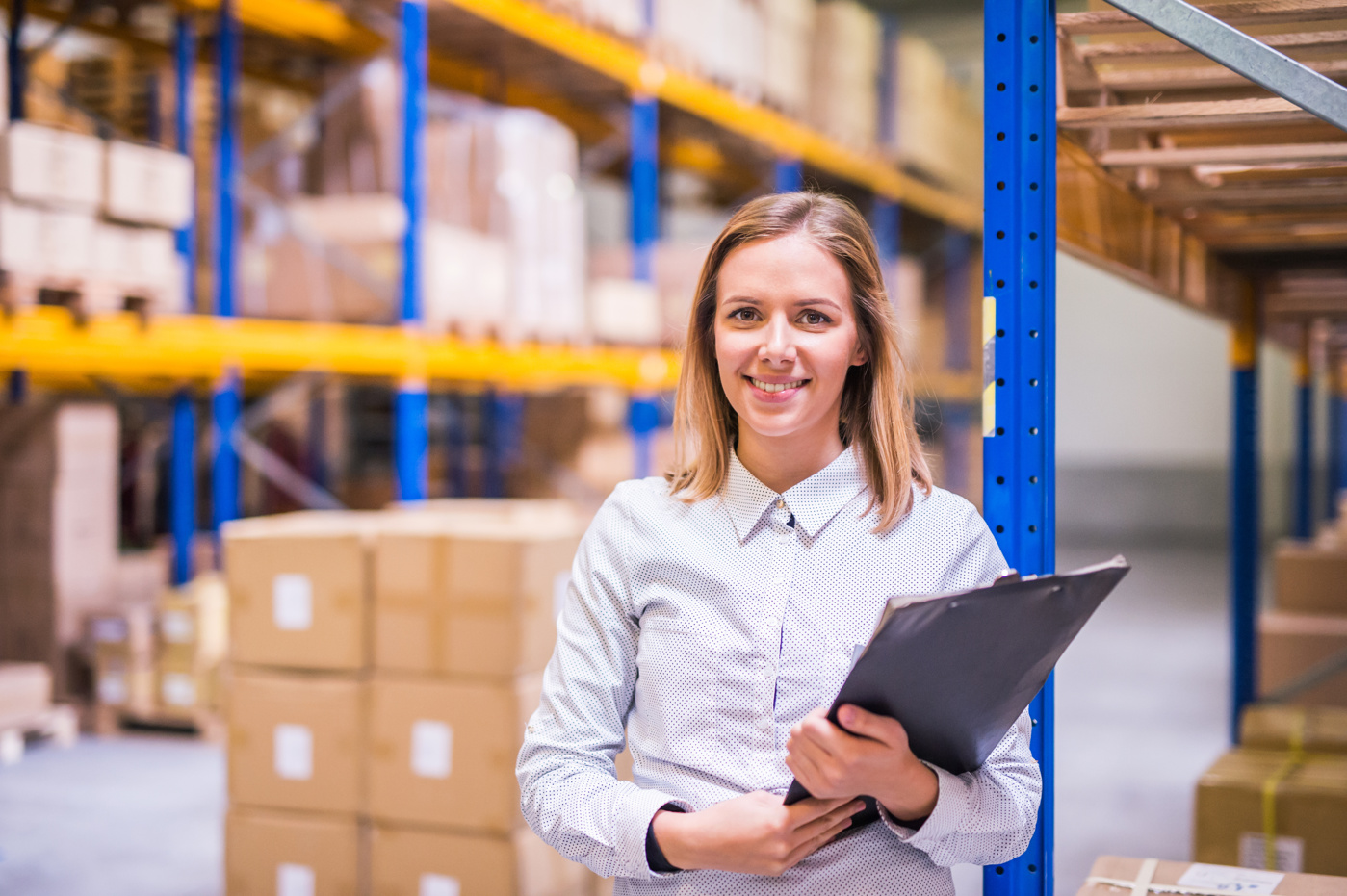 Eine Logistikerin HF überwacht den Ein- und Ausgang der Ware im Lager.