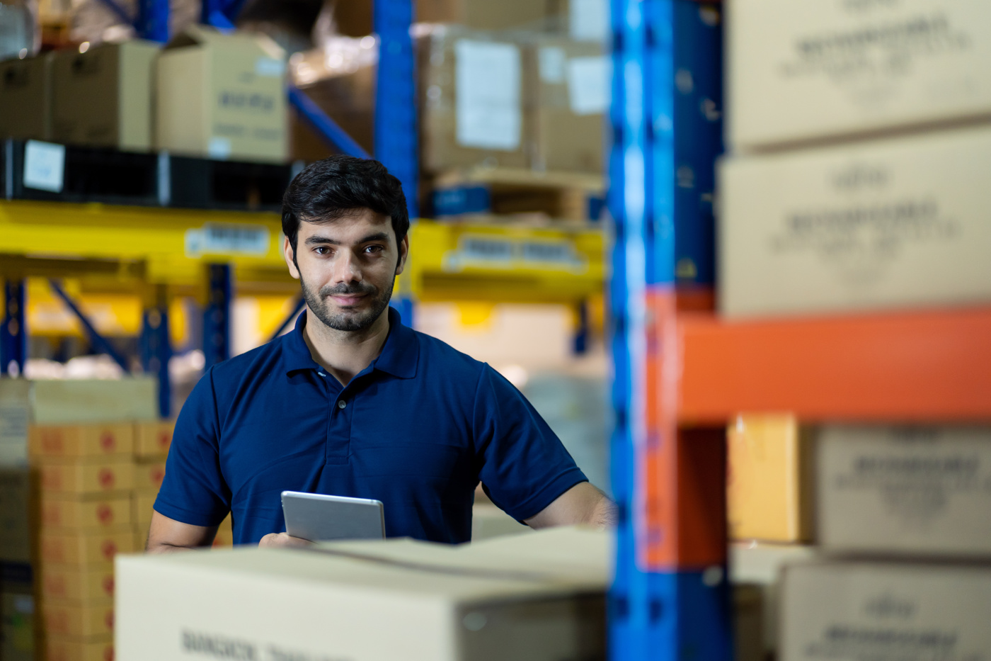 Ein Logistikfachmann mit eidg. Fachausweis steht im Lager um mögliche Optimierungsmassnahmen in den innerbetriebliche Logistikprozessen zu finden.