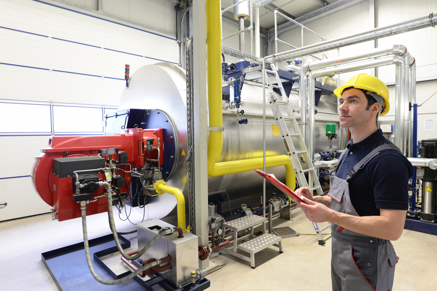 Ein Fachmann mit einem Maschinenbau HF Studium begutachtet eine Industrie-Maschine.