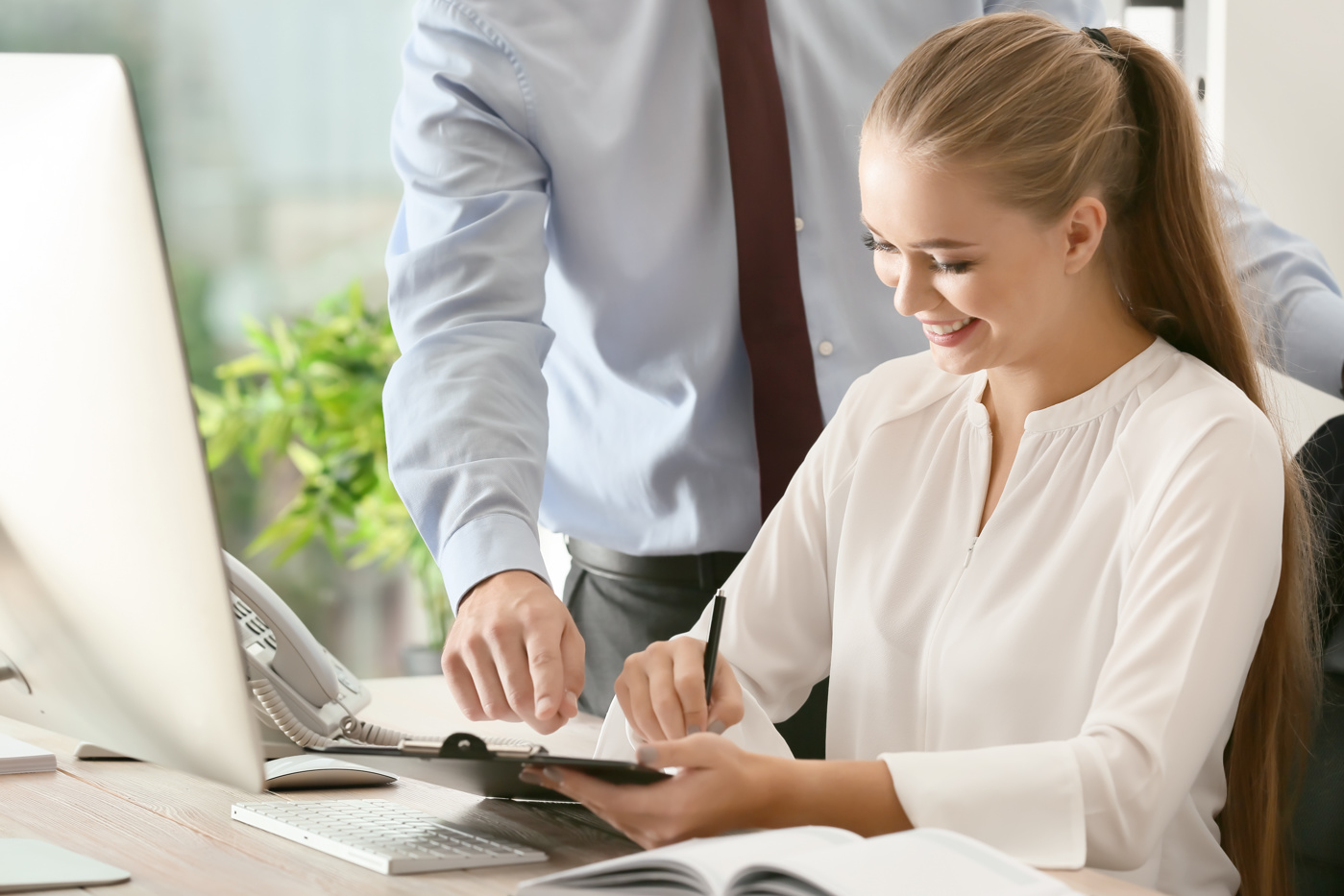 Eine HR-Assistentin bekommt Anweisungen von ihrem Vorgesetzten.