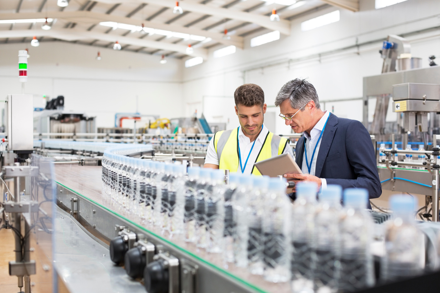 Qualitätsmanager überprüfen die Qualitätssicherungsmassnahmen in einer Produktion für Wasserflaschen.