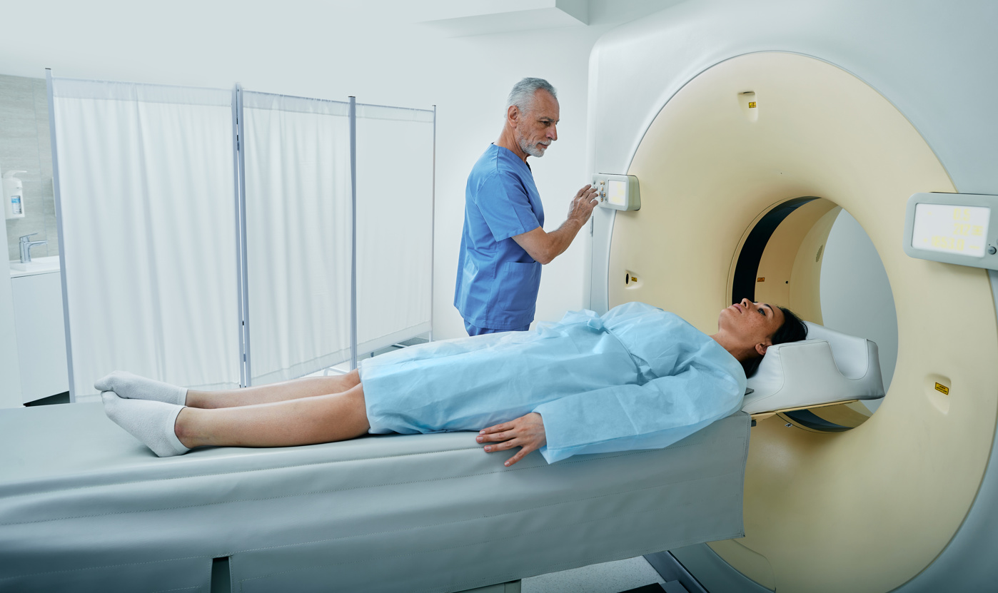 Eine Radiologiefachfrau HF platziert den Kopf einer Patientin korrekt unter dem Röntgengerät.