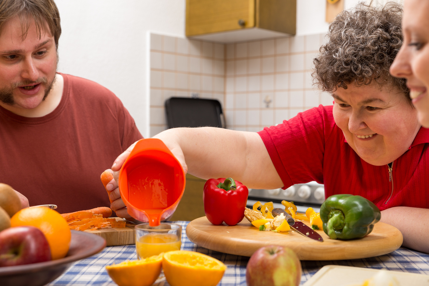 Eine Sozialpädagogin HF macht Orangensaft mit den Bewohnern einer sozialen Einrichtung.