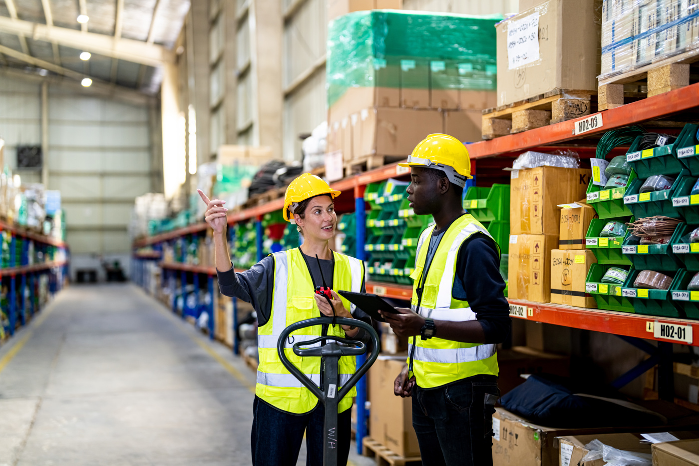 Eine Supply Chain Managerin mit eidg. Diplom gibt Anweisungen an einen Mitarbeiter.