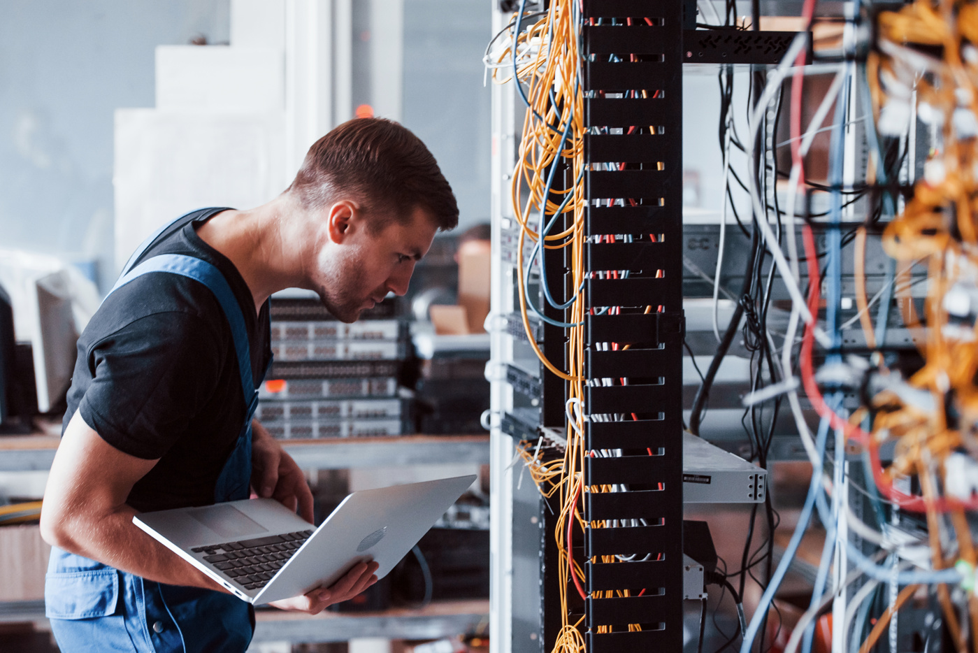 Ein Systemtechniker HF richtet elektrische Verbindungen für eine Anlage der Datenübertragung ein.