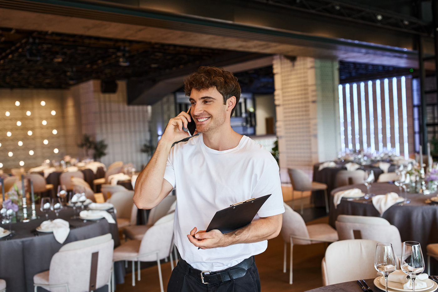 Ein Event Manager telefoniert mit dem Food-Lieferanten und koordiniert die Anlieferung der Ware.