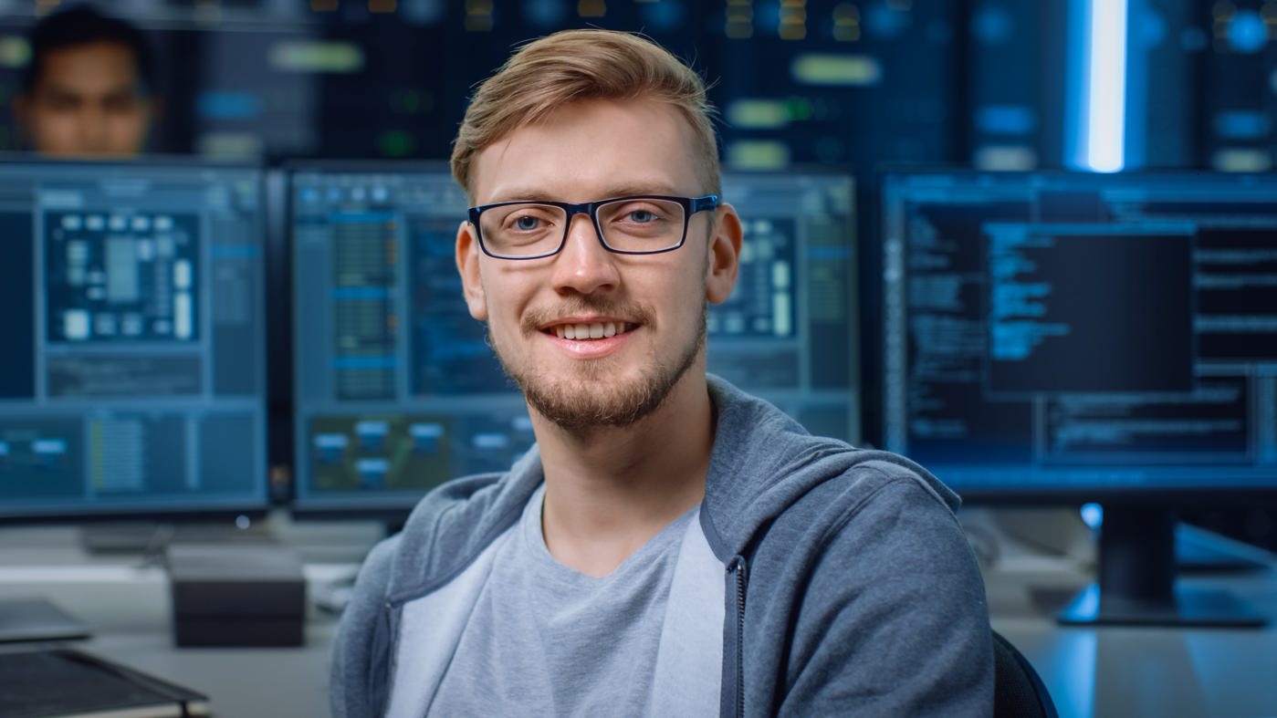 Cyber Security Specialist lächelt in die Kamera.