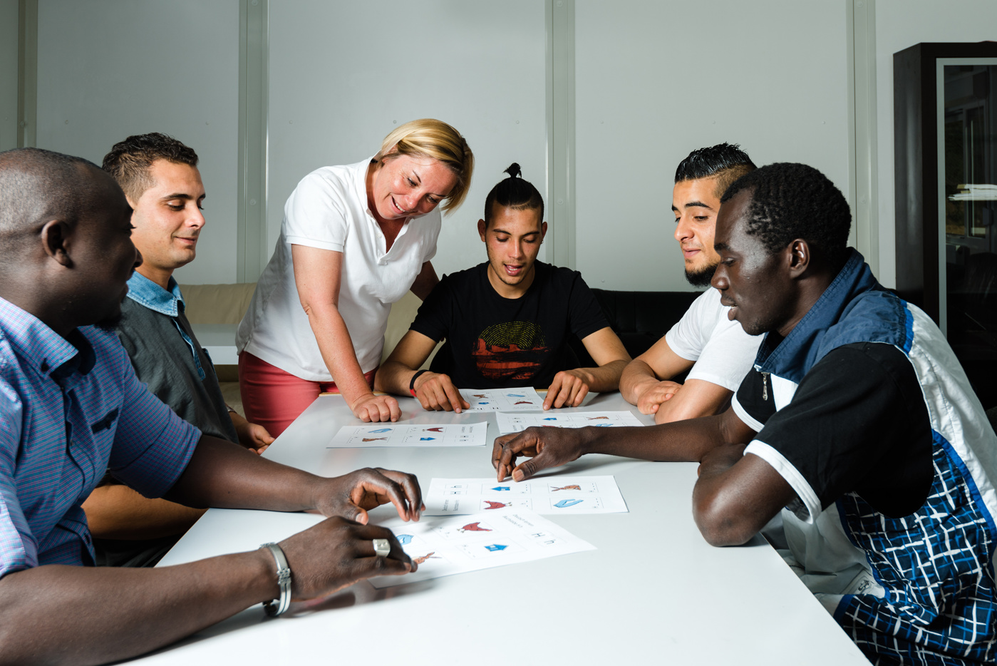 Eien Gruppe Personen, die neu in der Schweiz sind, belegen einen Kurs, um Deutsch zu lernen.