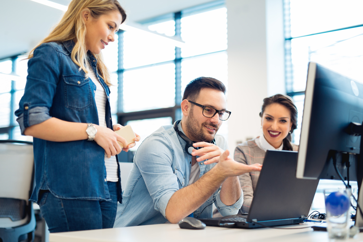 Teilnehmende eines Digital Business Management Kurses diskutieren über die zu lösende Aufgabe.
