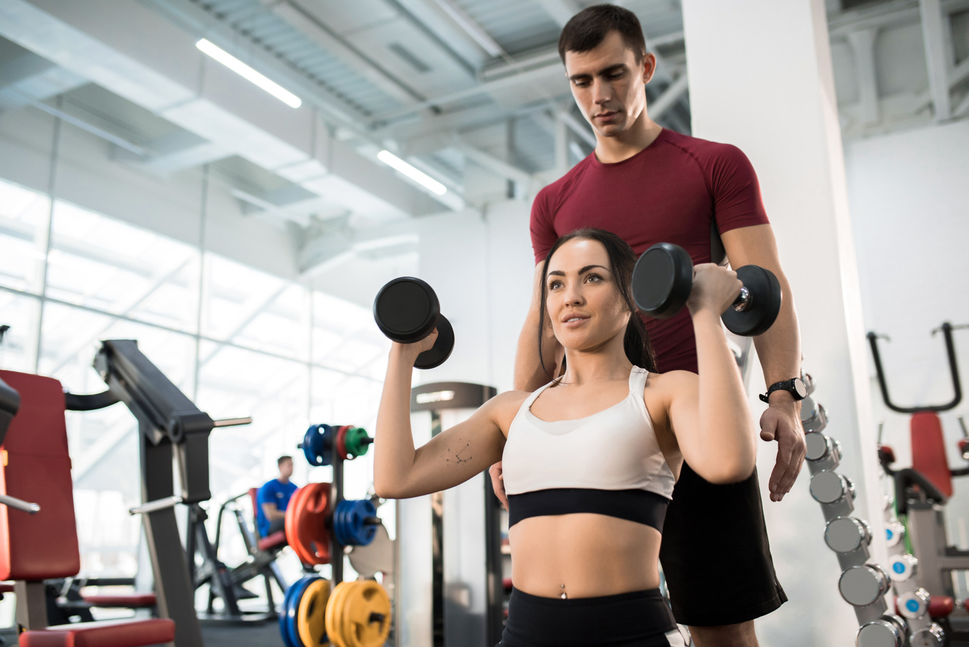 Ein Fitnessinstruktor betreut eine Kundin