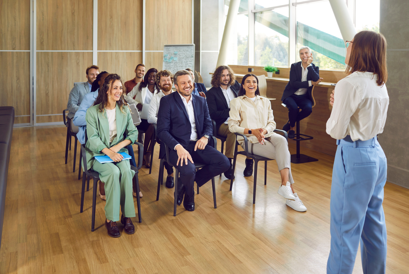 Teilnehmende eines Führungs-Seminars hören der Dozentin aufmerksam zu.