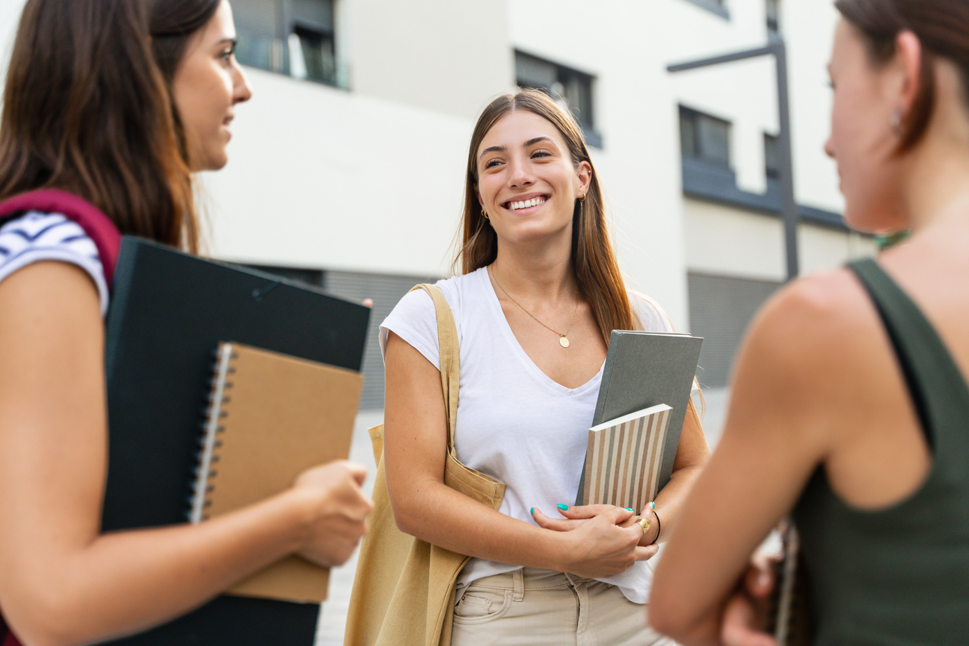Drei Frauen versammeln sich vor einer Italienisch Schule, um gemeinsam in den Unterricht zu gehen.