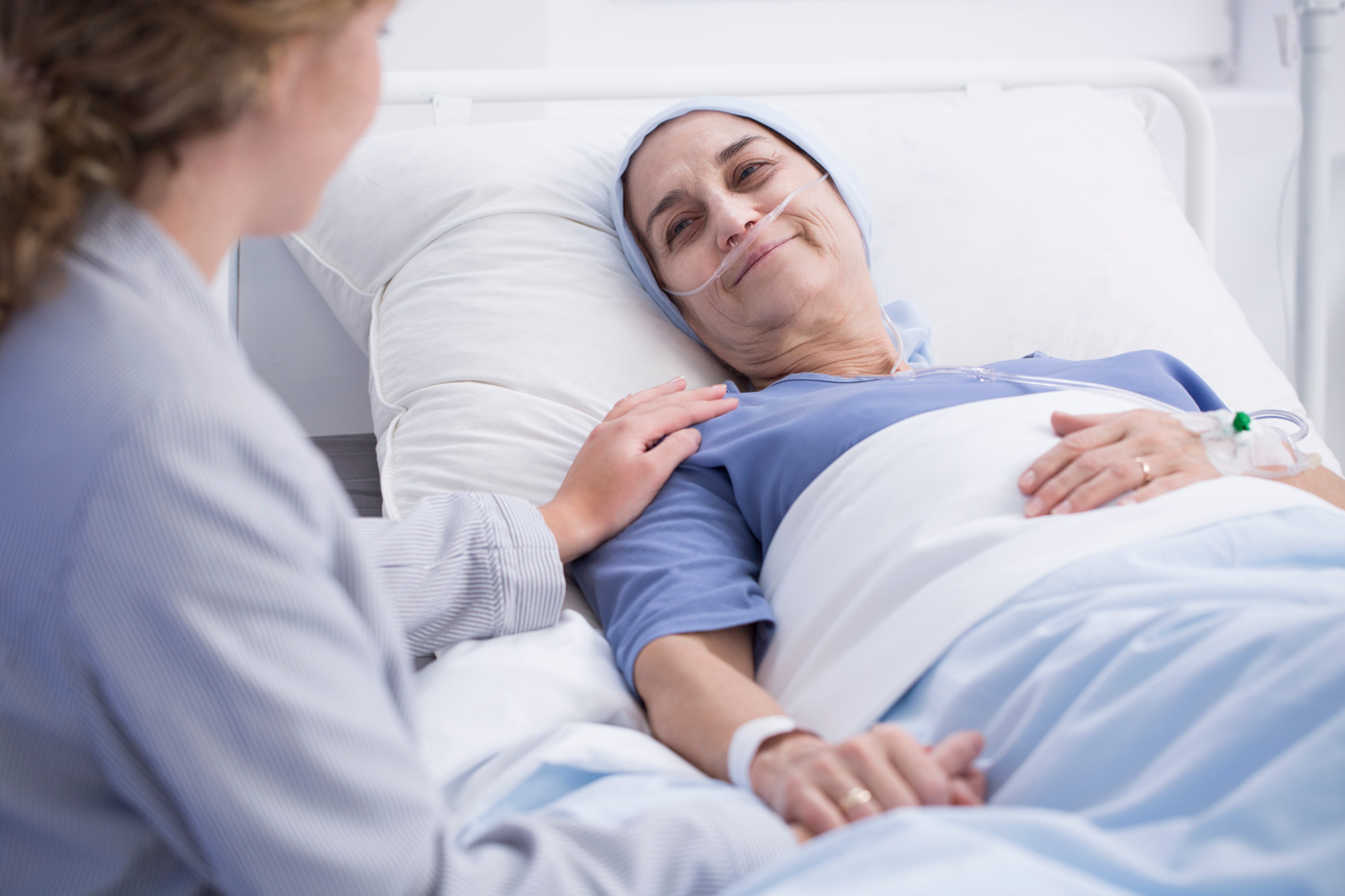 Eine Krankenschwester, die spezialisiert auf Sterbebegleitung ist, kümmert sich um eine Patientin.