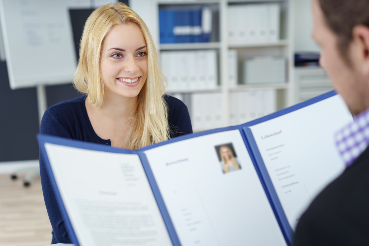 Ein Personalleiter im Bewerbungsgespräch mit einer Kandidatin.
