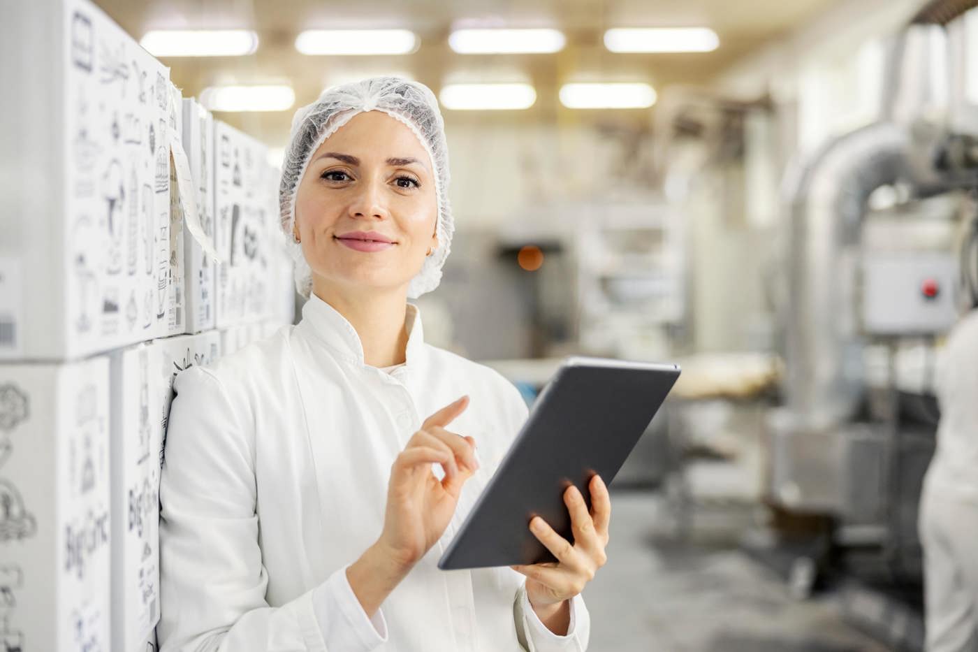 Eine Spezialistin kontrolliert die Qualität der Ware in einer Produktionshalle.