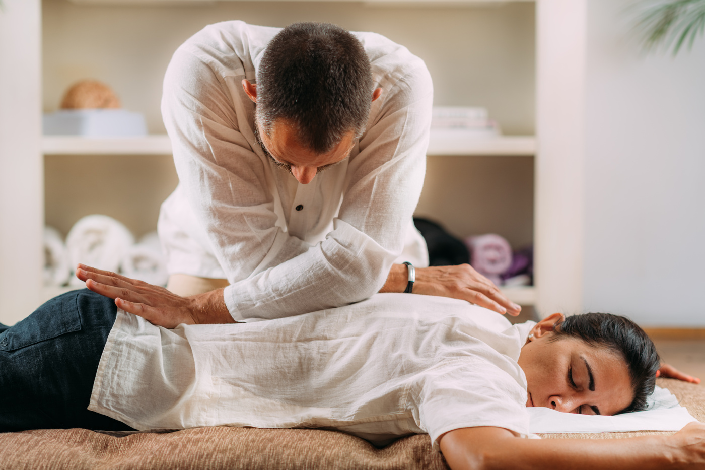 Eine Frau nimmt eine Shiatsu-Massage in Anspruch, um ihre Verspannungen im Rücken zu lösen.