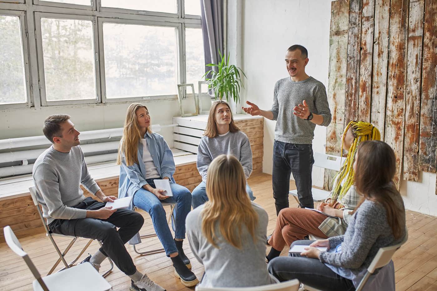 Eine Gruppe von Menschen, im Kreis sitzend, nehmen an einer Supervision teil.