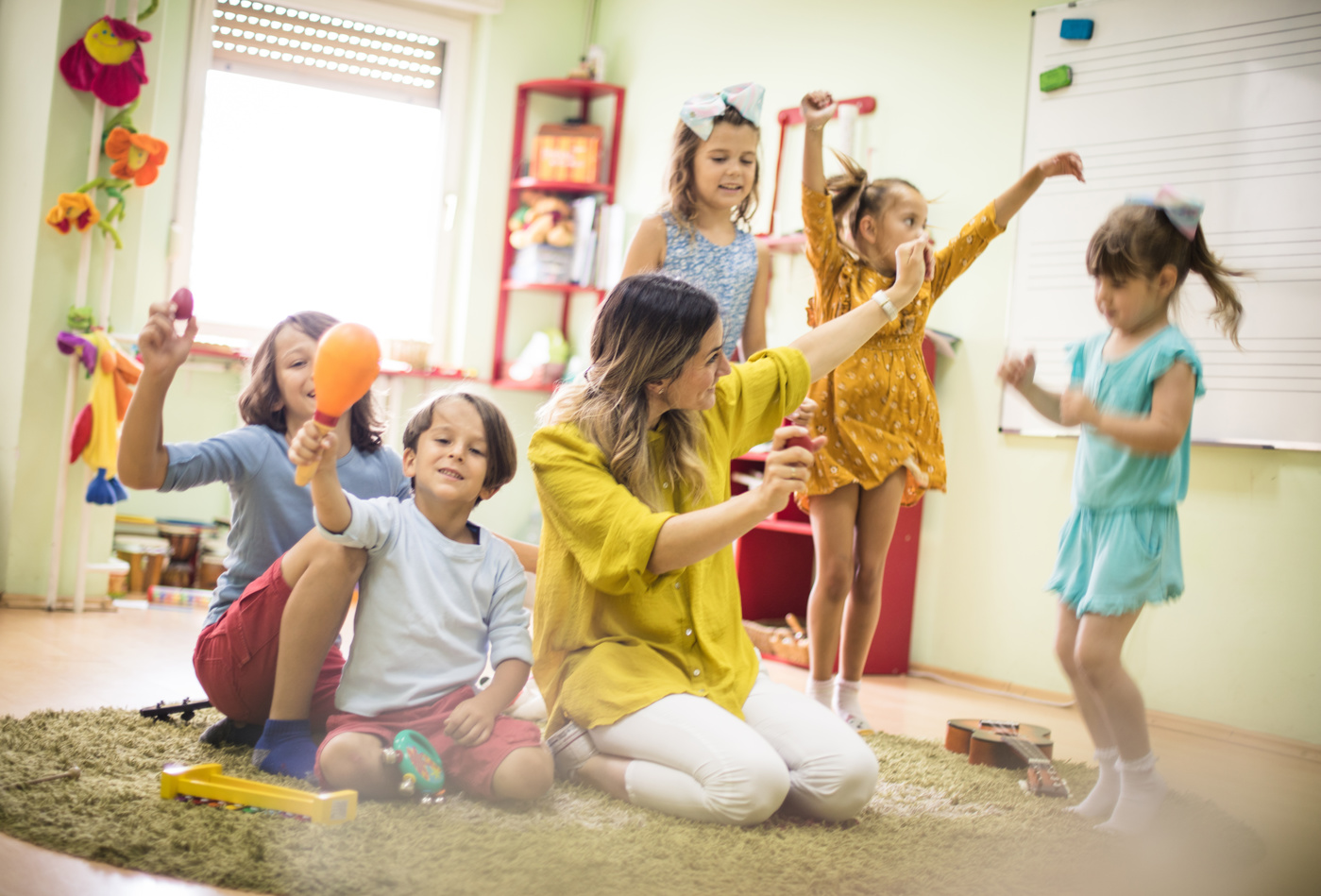 Eine Tanzpädagogin zeigt den Kindern verschiedene Bewegungen, um sich zu entspannen.
