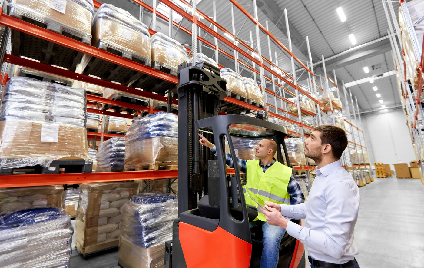 Ein technischer Kaufmann im Gespräch mit einem Logistik-Mitarbeiter