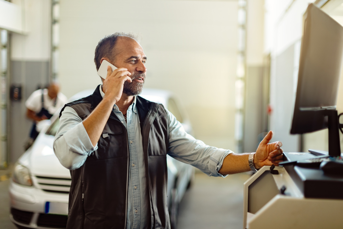 Ein Automobil-Werkstattkoordinator am Telefon mit einer Kundin.