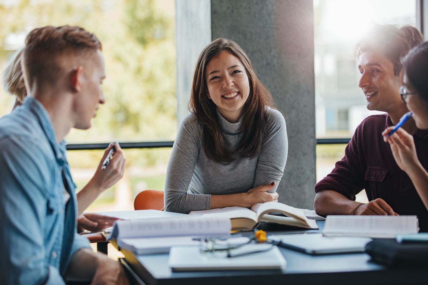 Schüler und Schülerinnen eines Wirtschaftsgymnasiums sind zusammen am lernen.