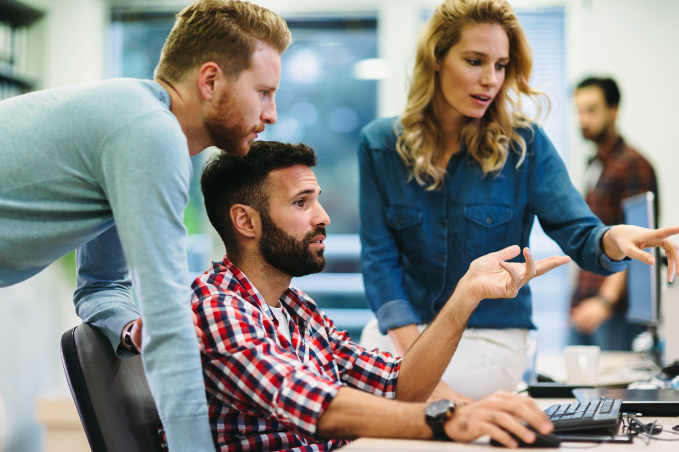 Wirtschaftsinformatiker besprechen ein Problem am PC